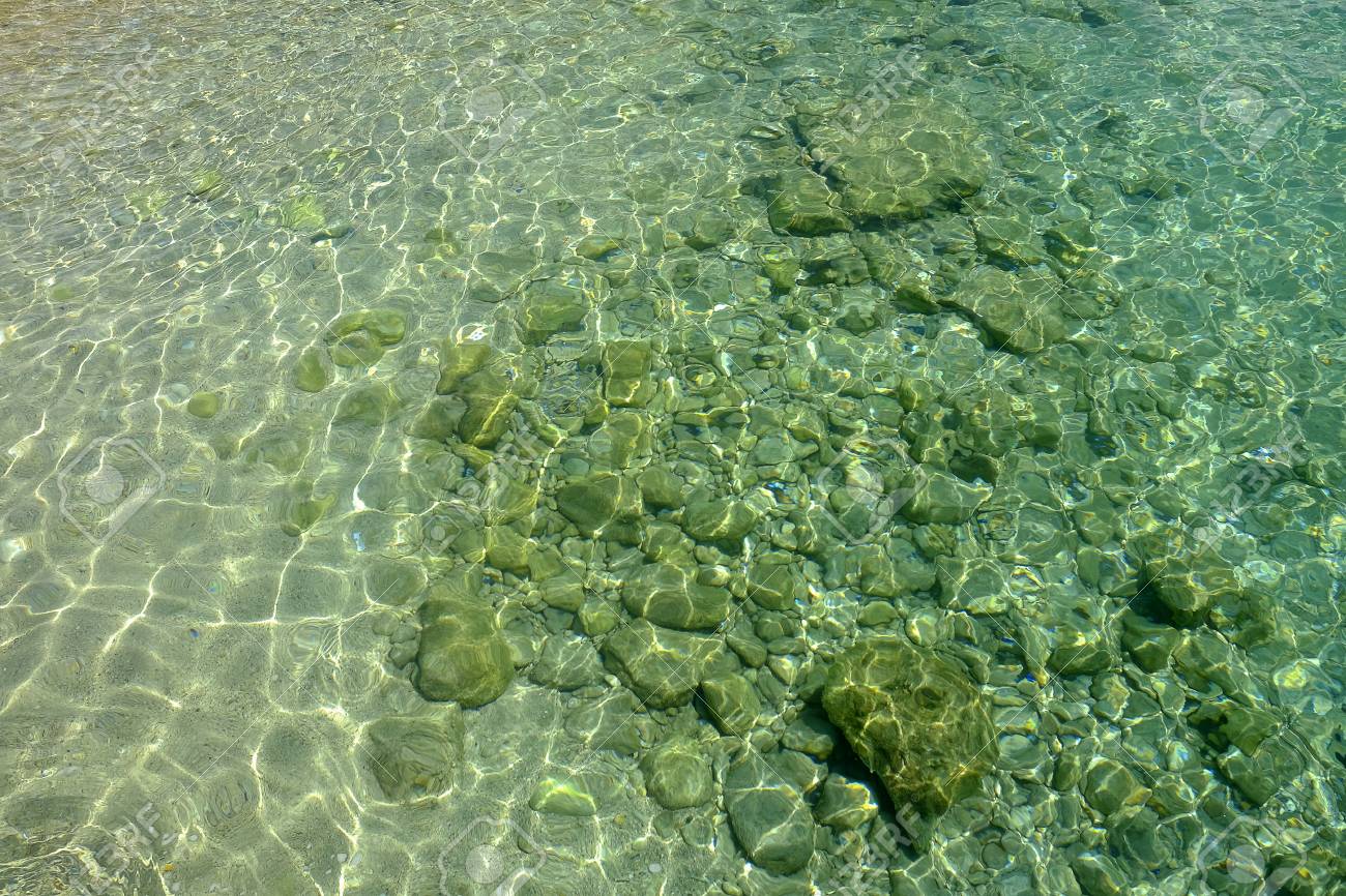 Crystal Sea Water And White Sand And Stones On The Ocean Floor
