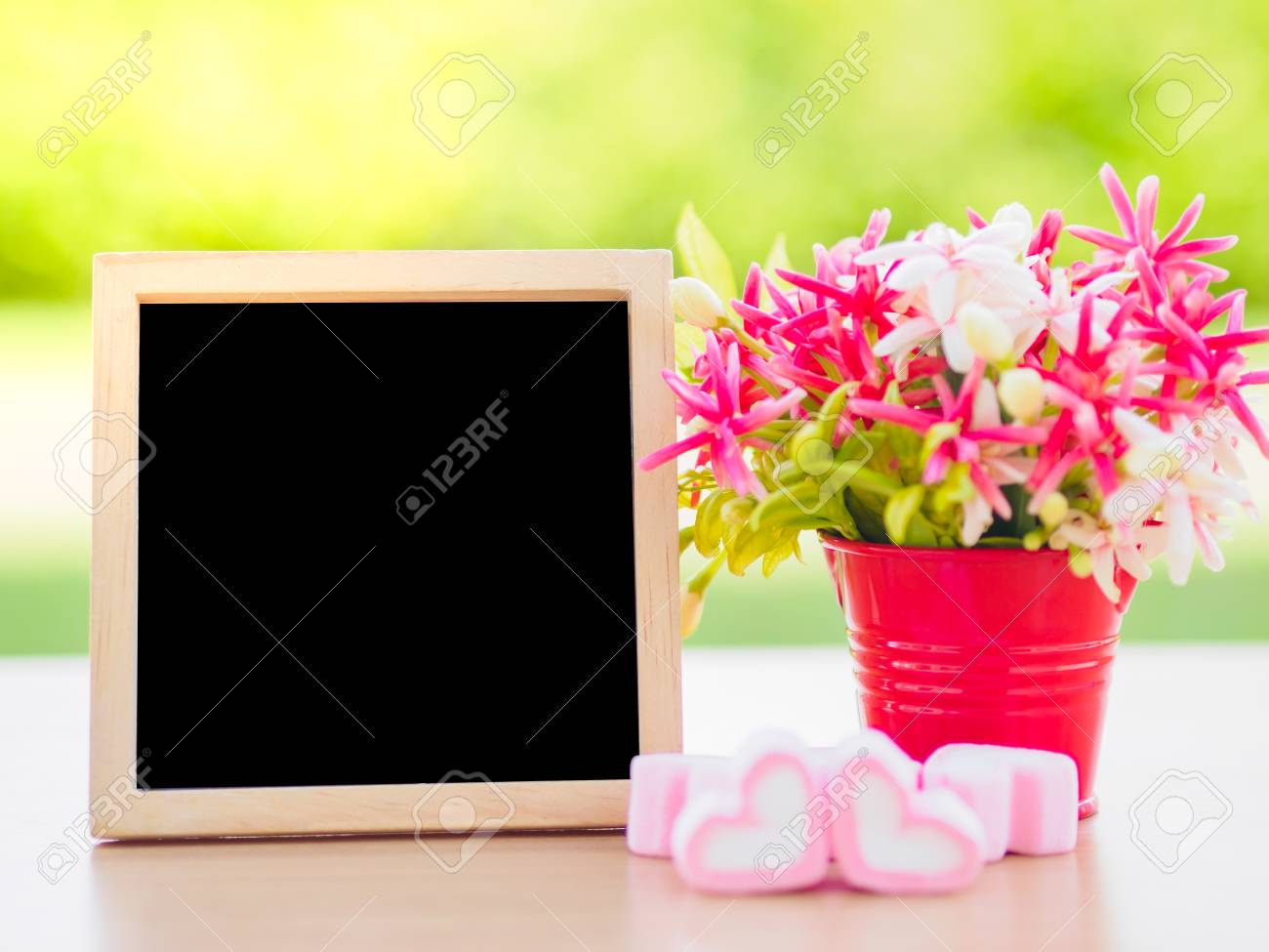 ポスターのモックアップを花の花束 心と緑の背景の上の本の形をしたマシュマロとテンプレート の写真素材 画像素材 Image