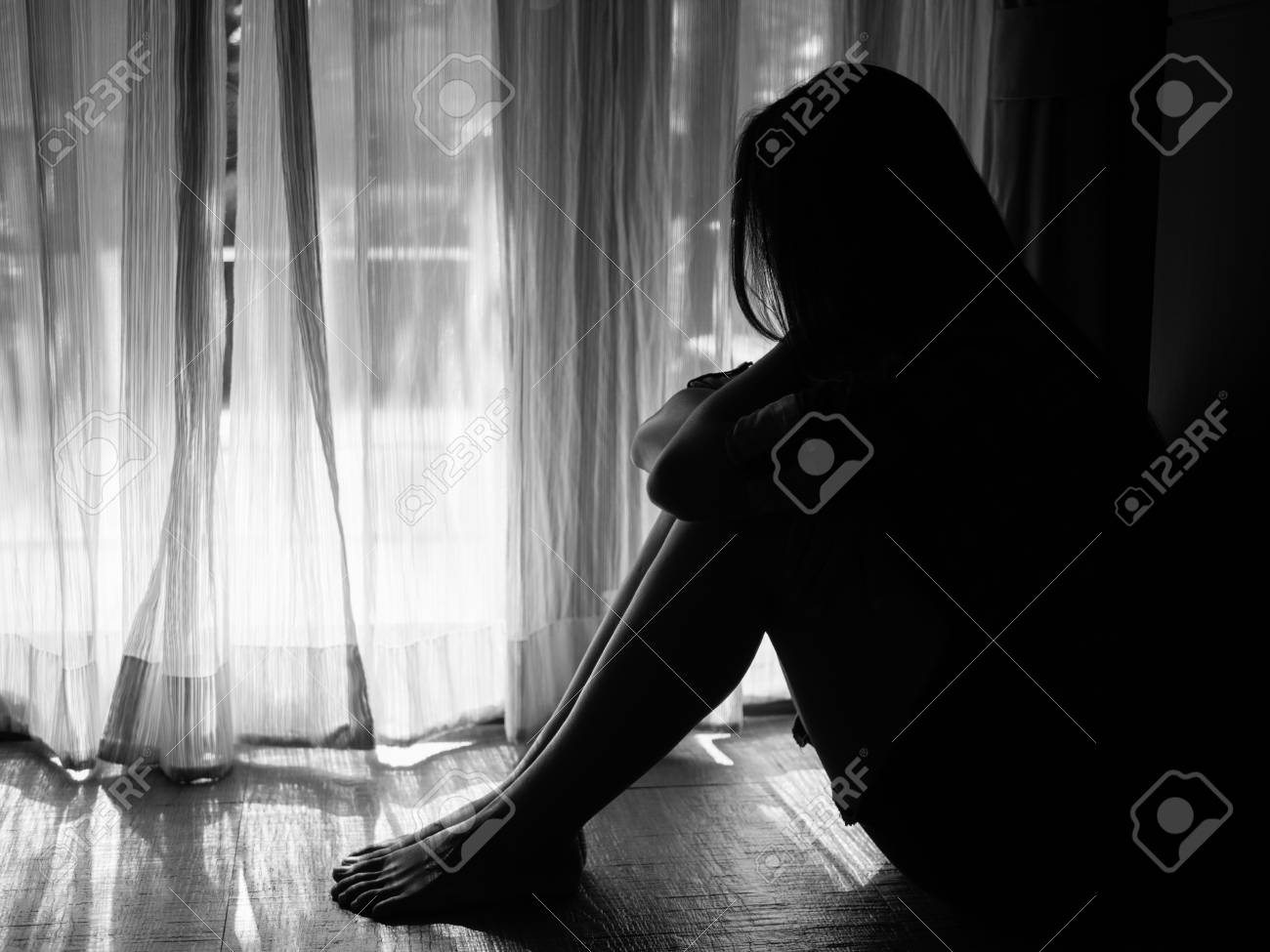 Black and white of sad woman hug her knee and cry sad woman sitting alone
