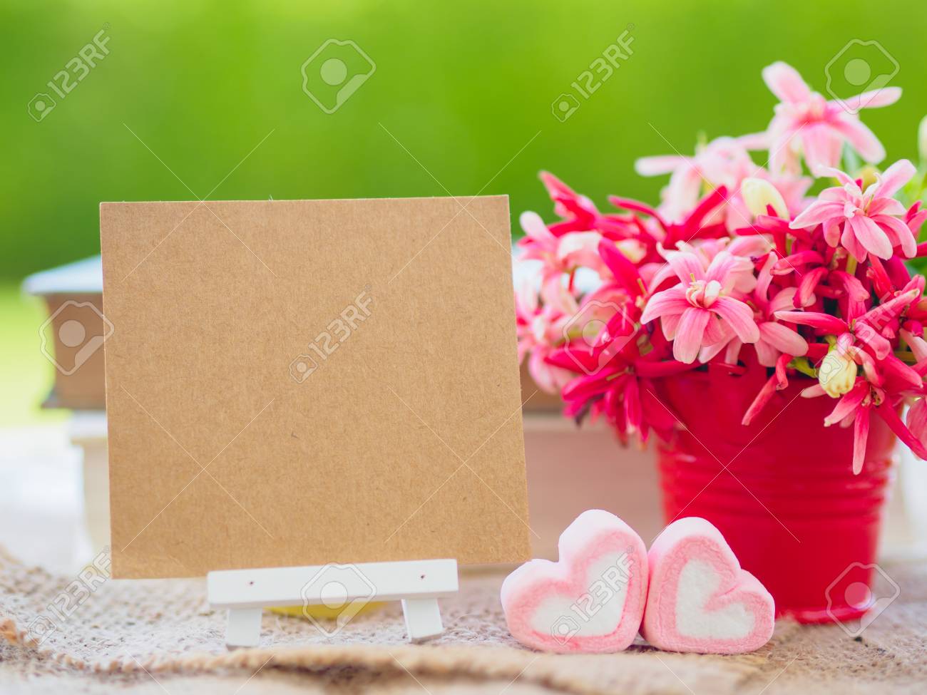 ポスターのモックアップを花の花束 心と緑の背景の上の本の形をしたマシュマロとテンプレート の写真素材 画像素材 Image