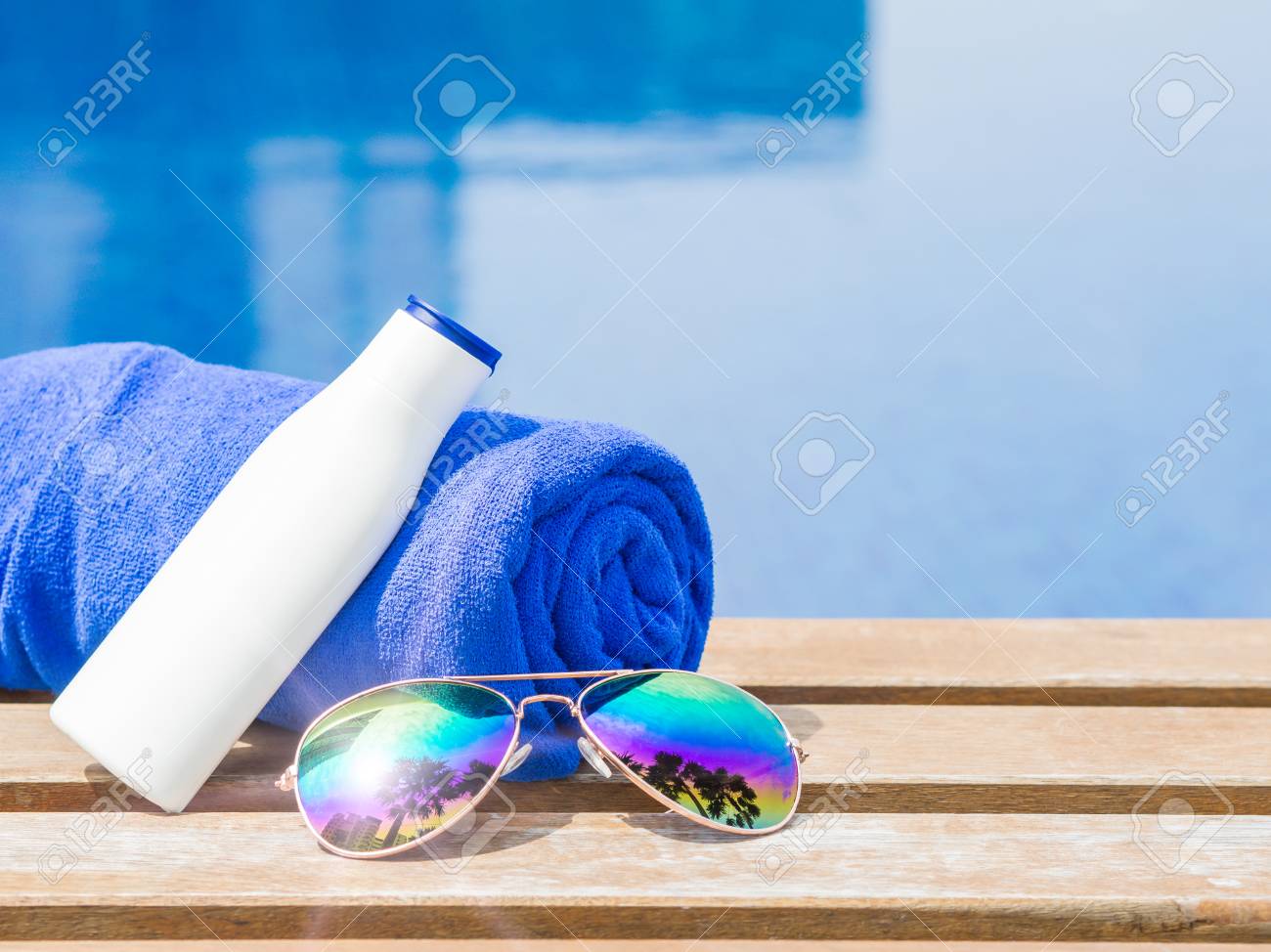 Lunettes De Soleil Serviette Bleue Et Crème Solaire Au Bord De La Piscine Vacances Plage Concept De Voyage Dété