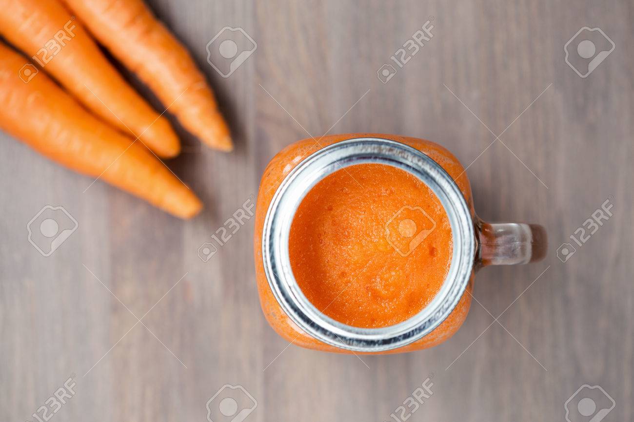 Healthy carrot smoothie in a jar with carrots on wooden background. Shallow dof - 47070291 Healthy carrot smoothie in a jar with carrots on wooden background. Shallow dof - 47070291