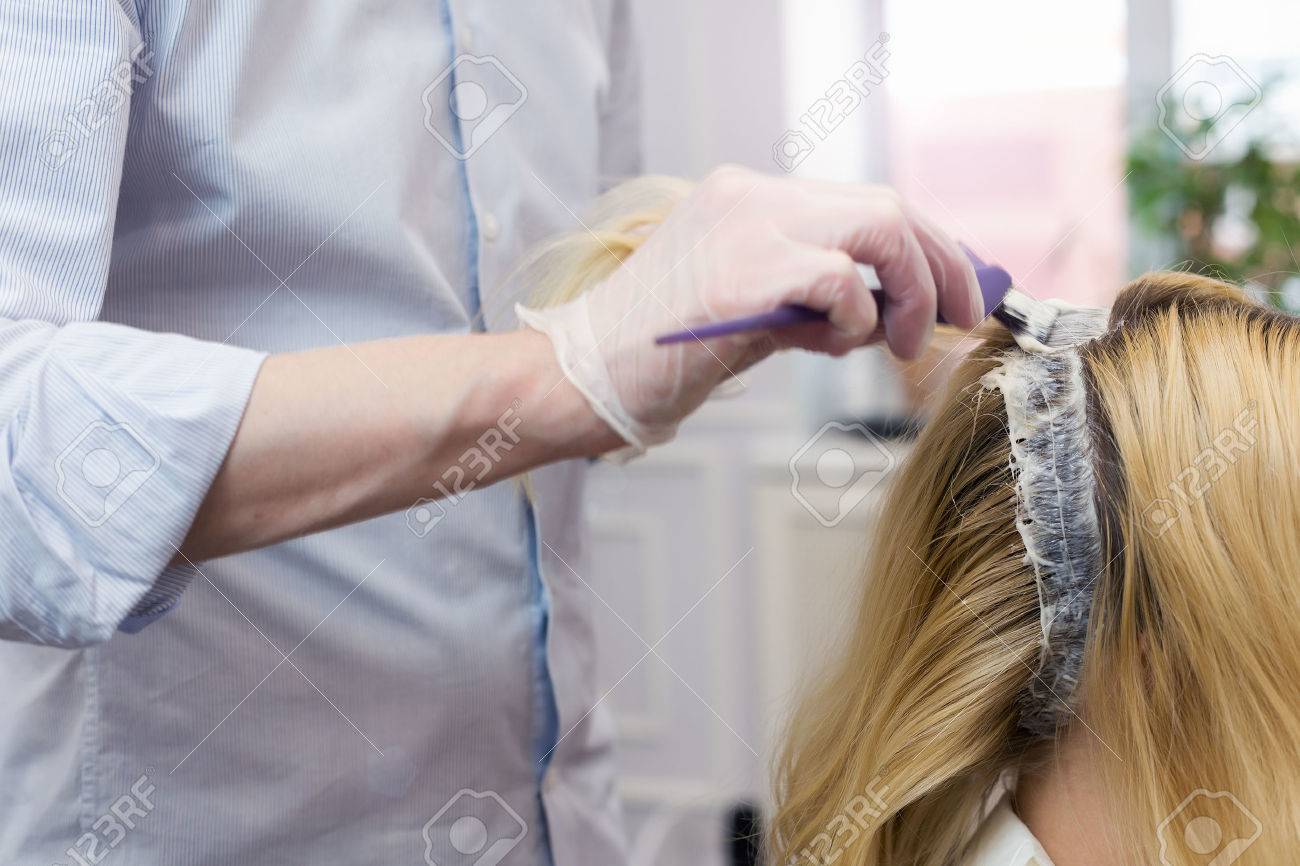 A blonde female bleaching hair in studio. Selective focus - 52593066 A blonde female bleaching hair in studio. Selective focus - 52593066
