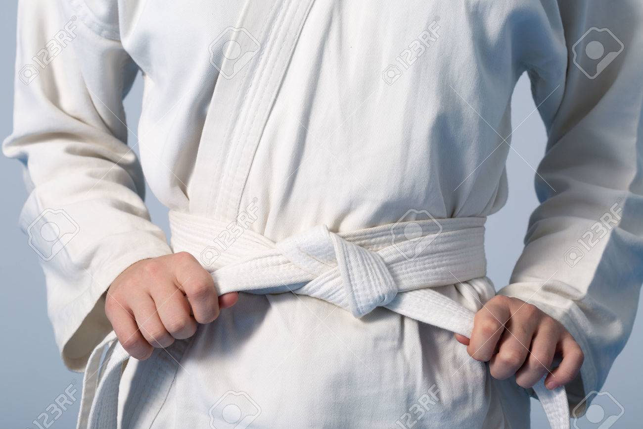 Hands tightening white belt on a teenage dressed in kimono for martial arts - 55408085 Hands tightening white belt on a teenage dressed in kimono for martial arts - 55408085