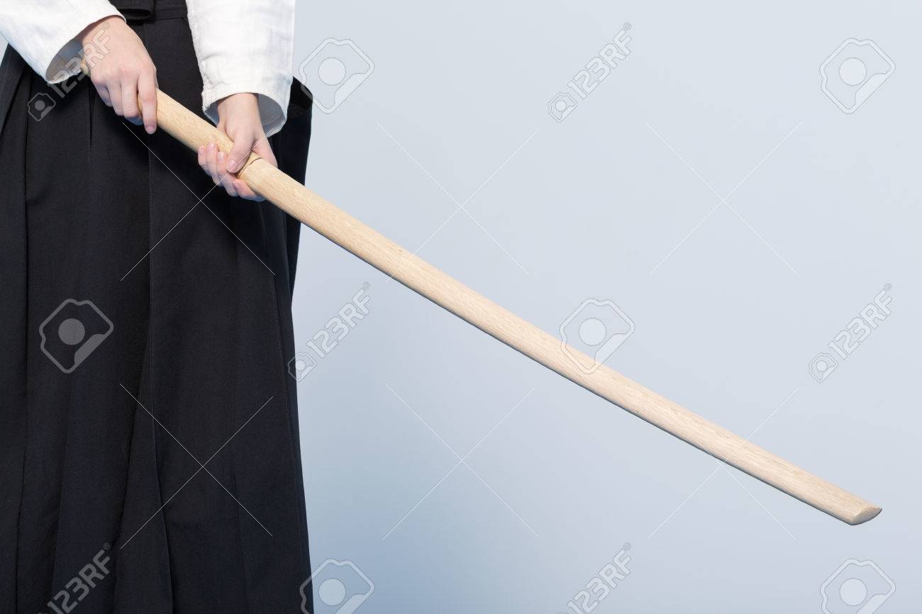 A girl in black hakama standing in fighting pose with wooden sword bokken - 61596834 A girl in black hakama standing in fighting pose with wooden sword bokken - 61596834