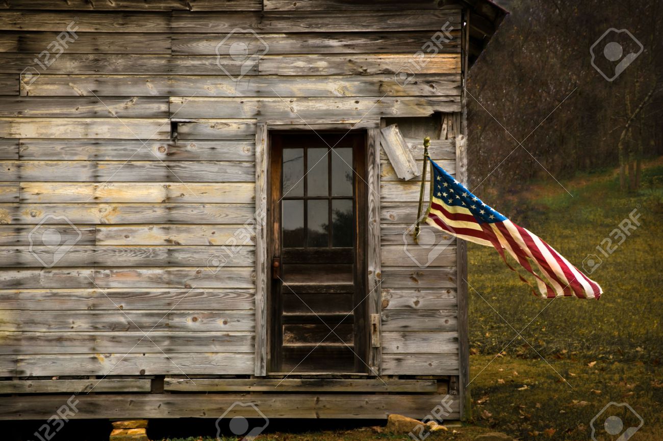 American Flag Hanging From An Old Barn With Negative Space To