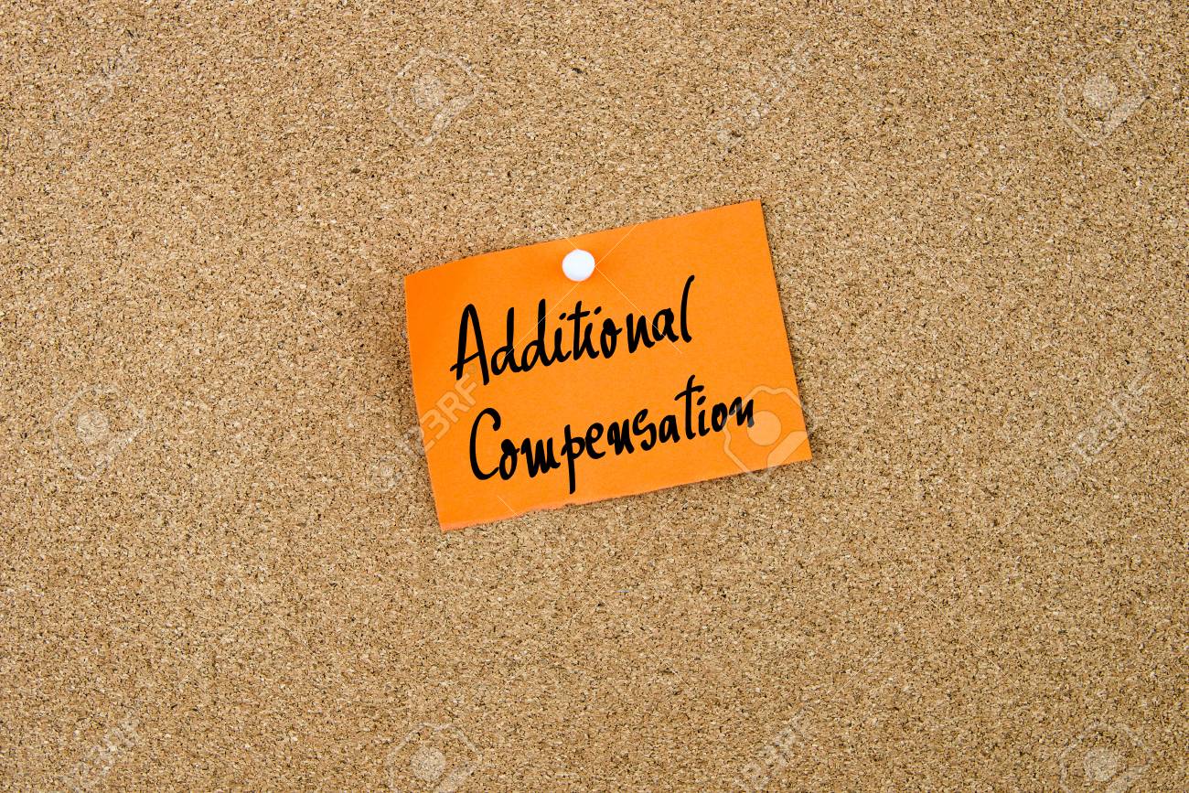 白い画鋲 コピー領域をコルクボードにピン留めメモ オレンジ色の紙に書かれた追加の補償 の写真素材 画像素材 Image