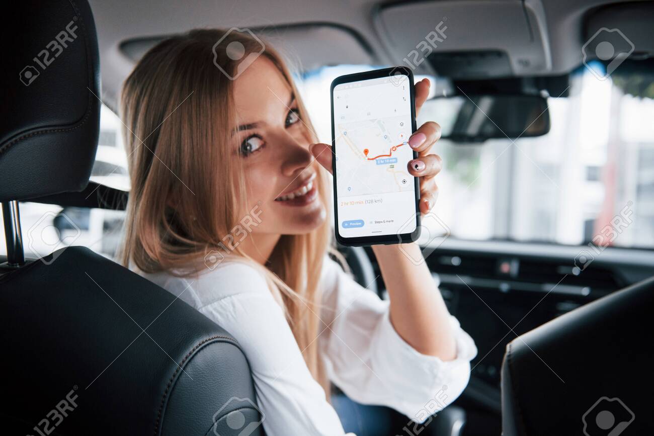 How far can I go. Beautiful blonde girl sitting in the new car with modern black interior. - 135889373 How far can I go. Beautiful blonde girl sitting in the new car with modern black interior. - 135889373