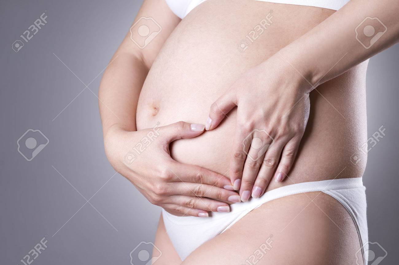 灰色のスタジオの背景に腹部の痛みで白いランジェリーの白人妊婦 妊娠の概念 の写真素材 画像素材 Image