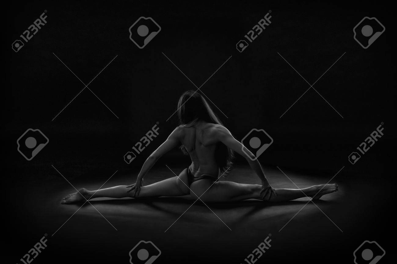Beautiful Muscular Naked Woman Doing Front Split With Right Leg Forward.  Hanumanasana On A Black Background. Studio Shot Stock Photo, Picture and  Royalty Free Image. Image 56973953.