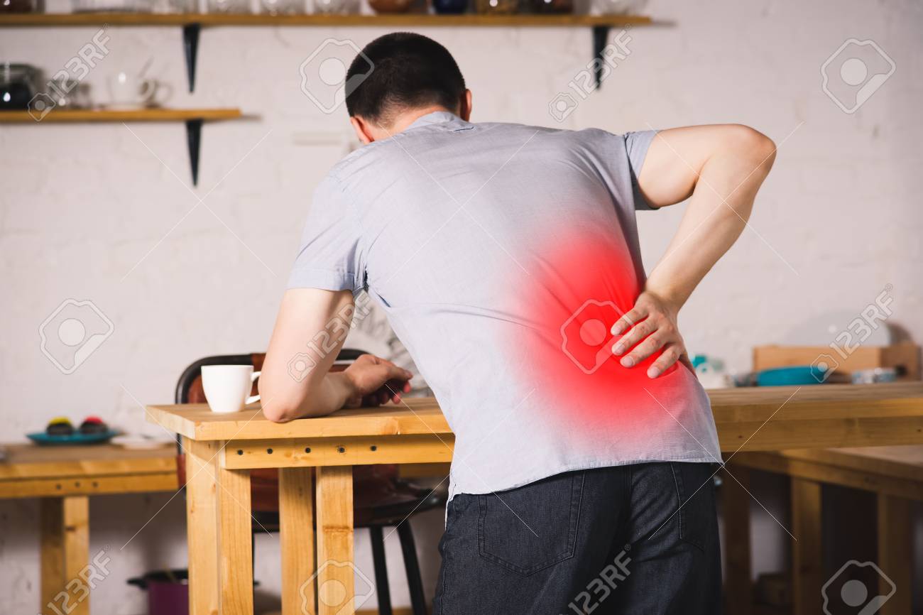 Back pain, kidney inflammation, man suffering from backache at home, painful area highlighted in red - 107008650 Back pain, kidney inflammation, man suffering from backache at home, painful area highlighted in red - 107008650