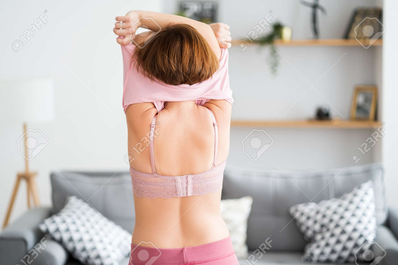 Mujer Desnudándose Y Desenganchándose El Sostén En Casa Fotos, retratos,  imágenes y fotografía de archivo libres de derecho. Image 187655121