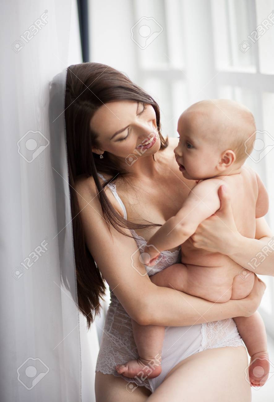 La Jeune Mere Tient Son Bebe Nu Sur Les Mains Ils Sont Assis Et Souriants Banque D Images Et Photos Libres De Droits Image