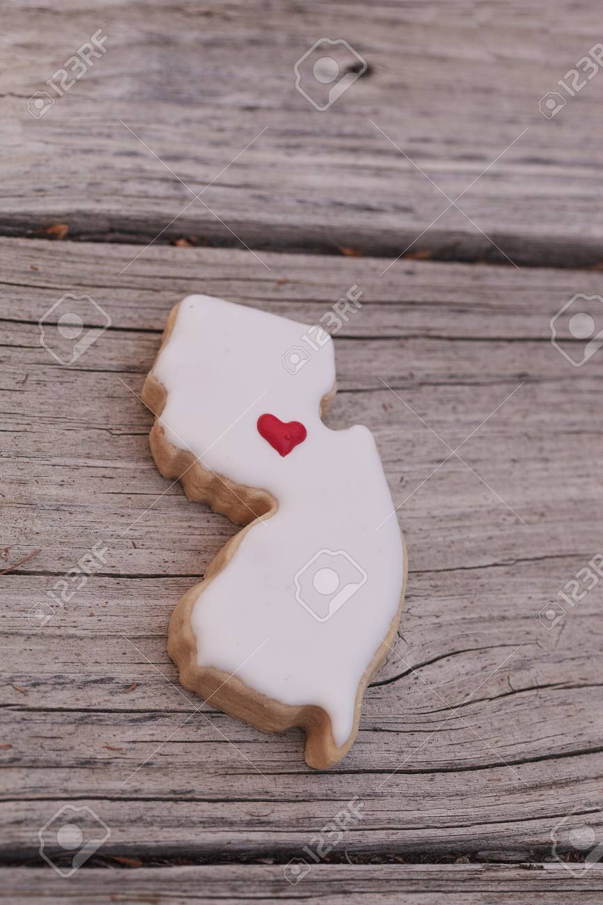 California Shaped Sugar Cookie With White Icing And A Red Heart On Rustic Wood Table California Shaped Sugar Cookie With White Icing And A Red Heart On Rustic Wood Table