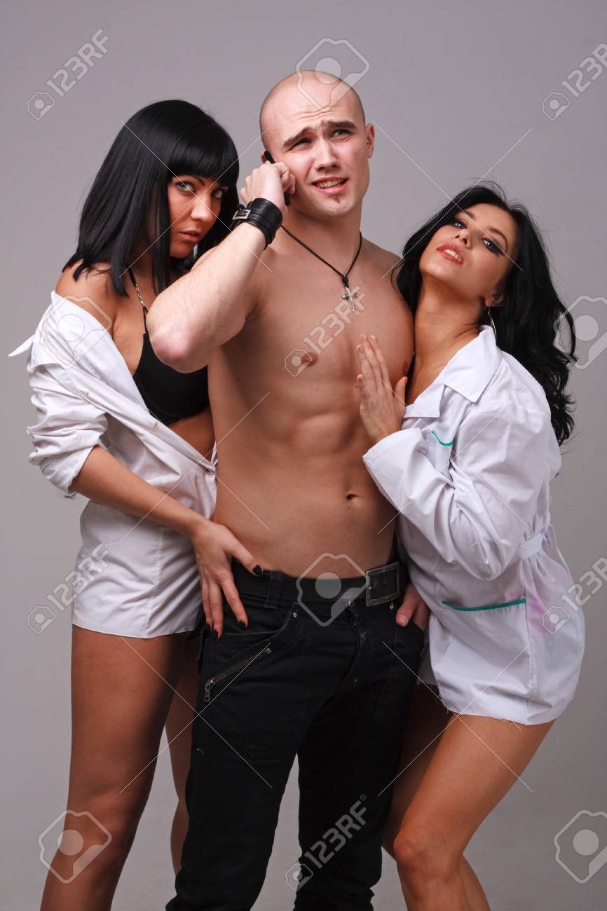 Two Sexy Girls And Boy On A Grey Background Stock Photo, Picture and Royalty Free Image