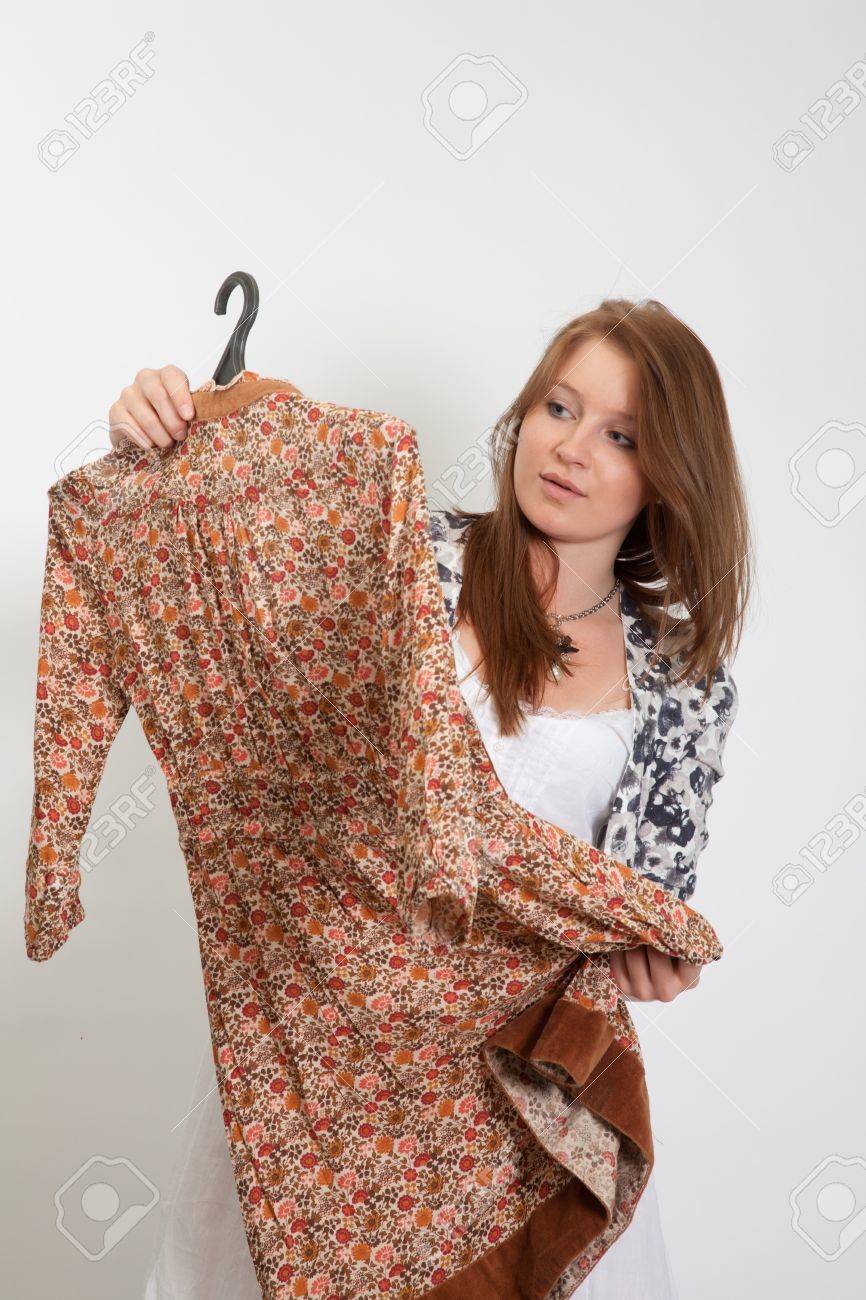 The girl considers a dress, intending it to buy - 9378387 The girl considers a dress, intending it to buy - 9378387