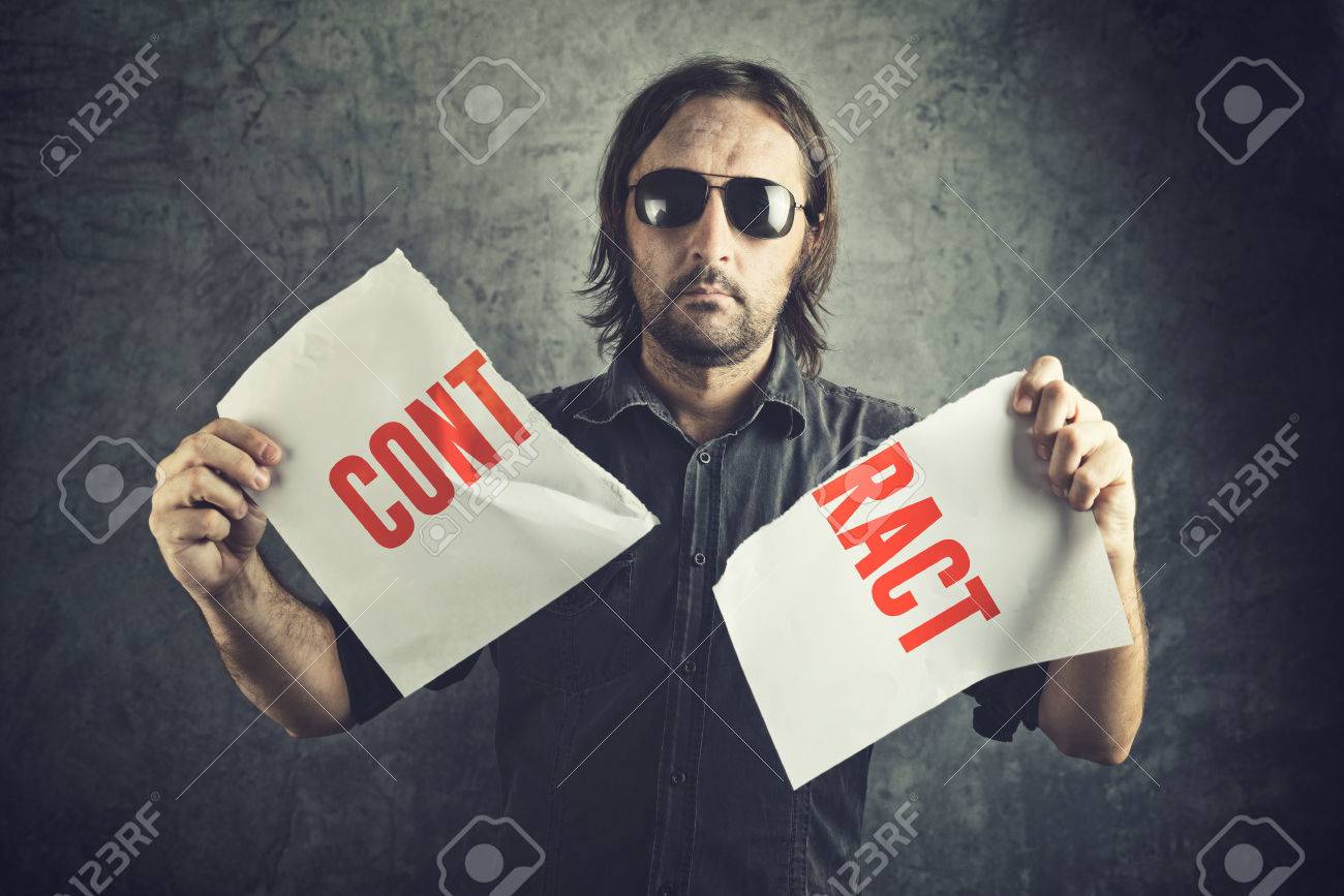 Man tearing apart contract document paper as a gesture of agreement cancellation. - 33150972 Man tearing apart contract document paper as a gesture of agreement cancellation. - 33150972