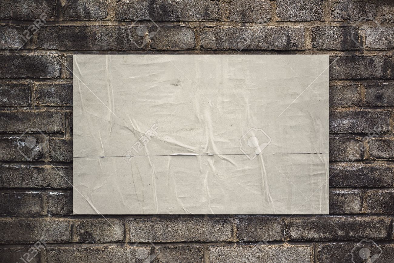 glued rustic blank poster paper as copy space on old brick wall
