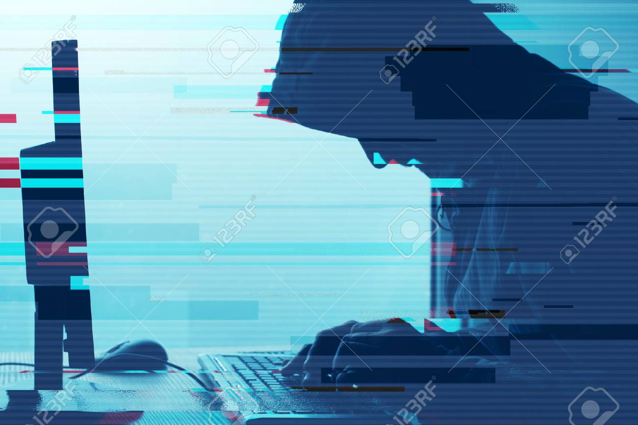 Hooded computer hacker working on desktop PC computer. P2P and piracy, computer virus and trojans, phishing, malware and ransomware concept with glitch effect. - 87910784 Hooded computer hacker working on desktop PC computer. P2P and piracy, computer virus and trojans, phishing, malware and ransomware concept with glitch effect. - 87910784
