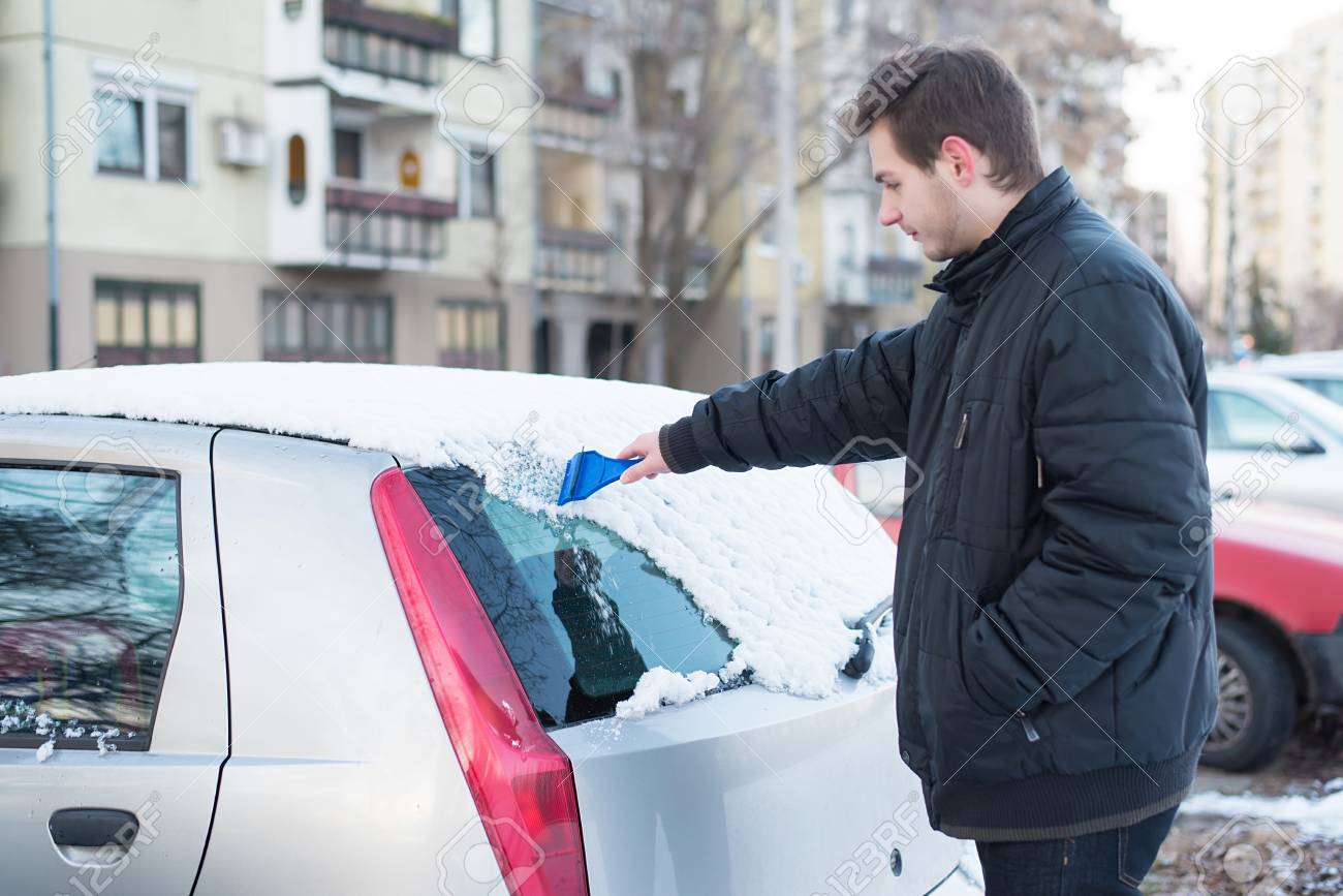 車のフロントガラスから雪と氷を削る男 の写真素材 画像素材 Image