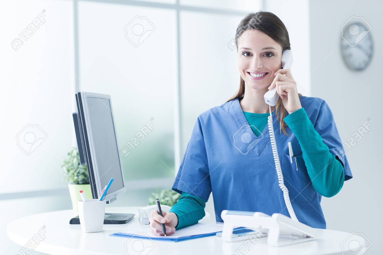 Young Female Doctor And Practitioner Working At The Reception Desk, She Is  Answering Phone Calls And Scheduling Appointments Stock Photo, Picture and  Royalty Free Image. Image 59972852., image size:1300x866