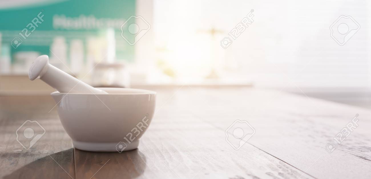 Mortar and pestle on the pharmacist's table and pharmaceutical products on the background - 98231407 Mortar and pestle on the pharmacist's table and pharmaceutical products on the background - 98231407