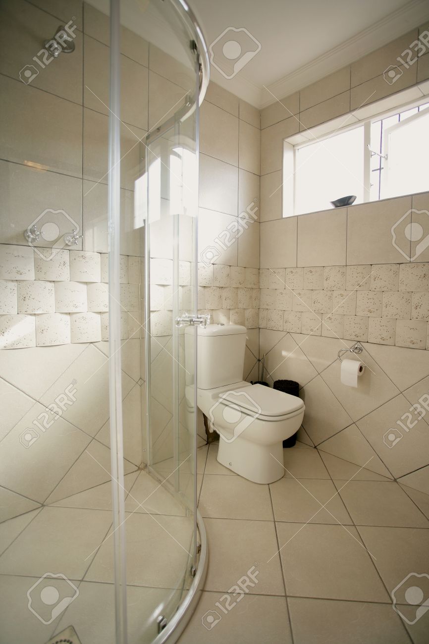 L'interno di un bagno beige e nero che mostra un wc doccia e le ...