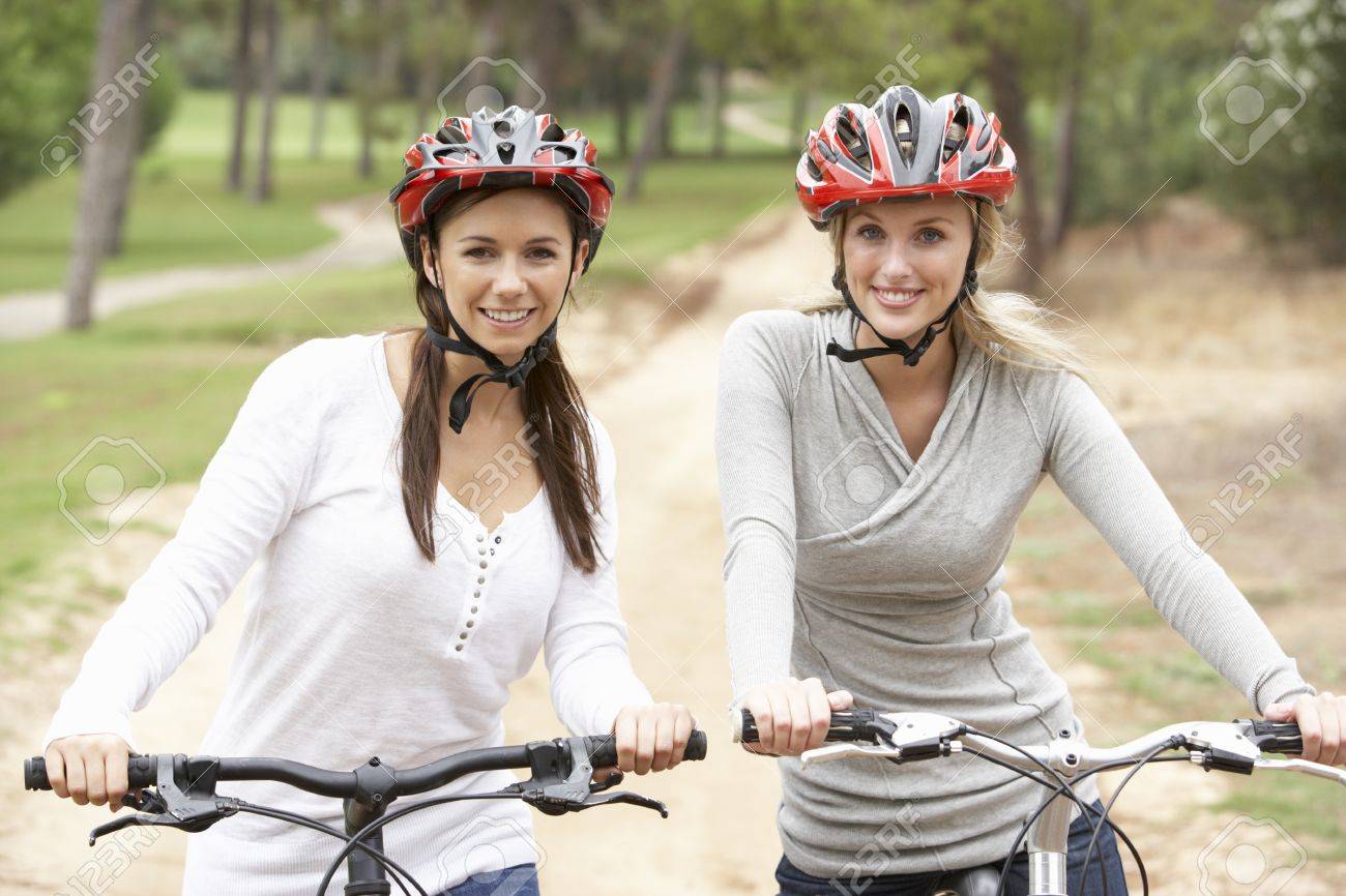 Two Female Friends Riding Bikes In Park Stock Photo Picture And Two Female Friends Riding Bikes In Park Stock Photo Picture And