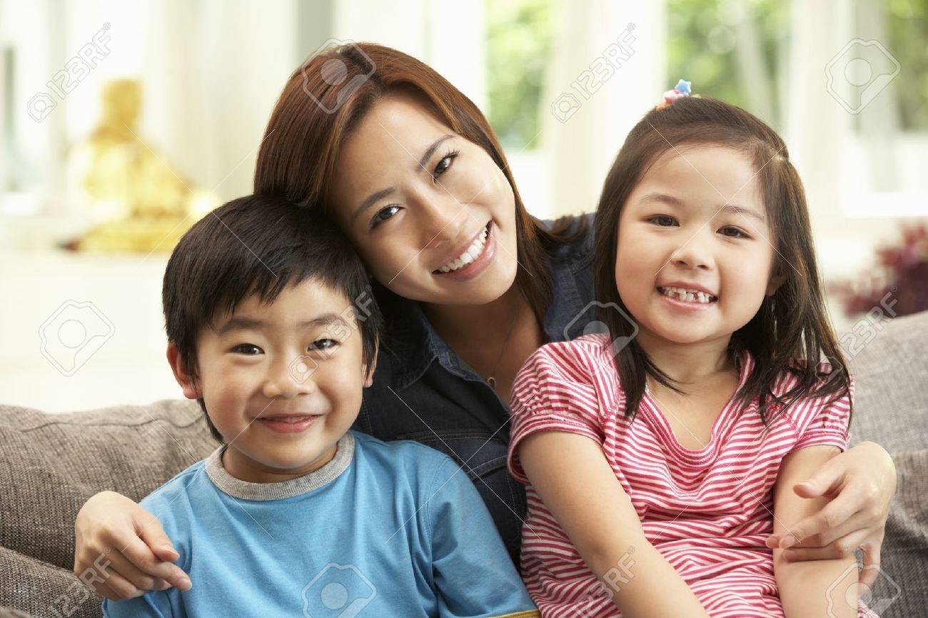 Chinese Mother And Children Sitting On Sofa At Home Together Stock Photo Picture And Royalty Free Image Image 18710519
