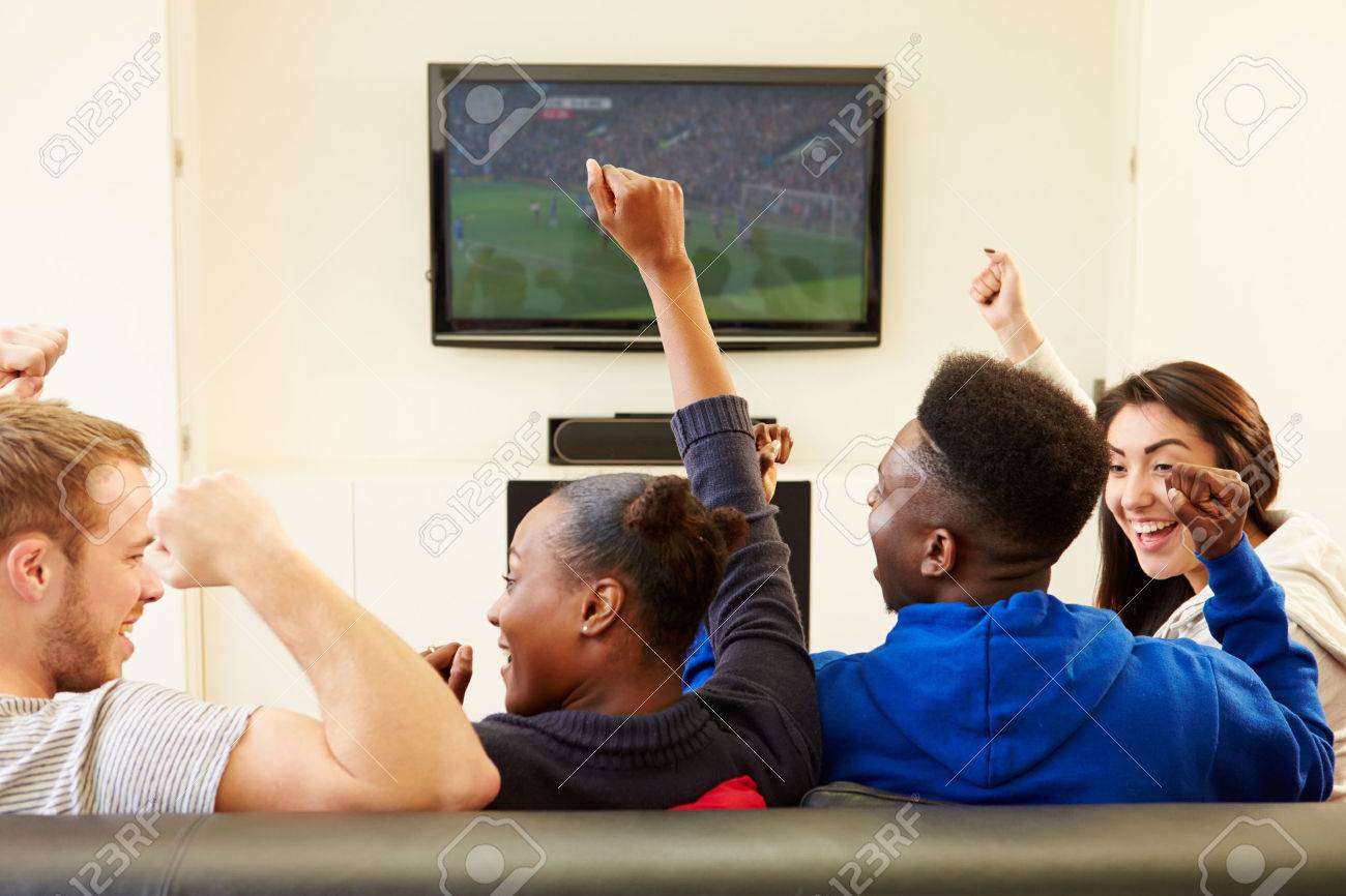 Two Young Couples Watching Television At Home Together - 31066394 Two Young Couples Watching Television At Home Together - 31066394