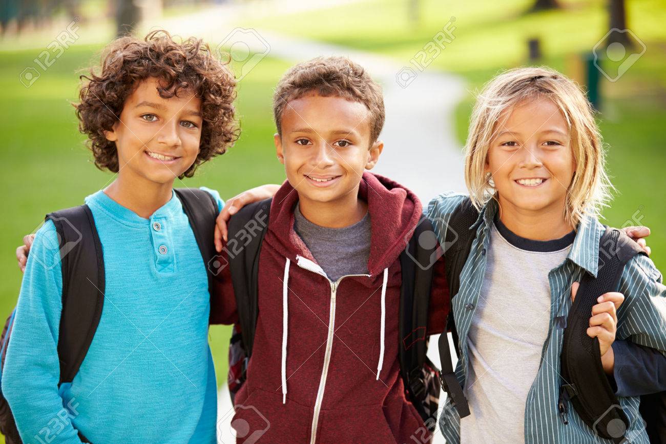 group of young boys hanging out in park together stock photo