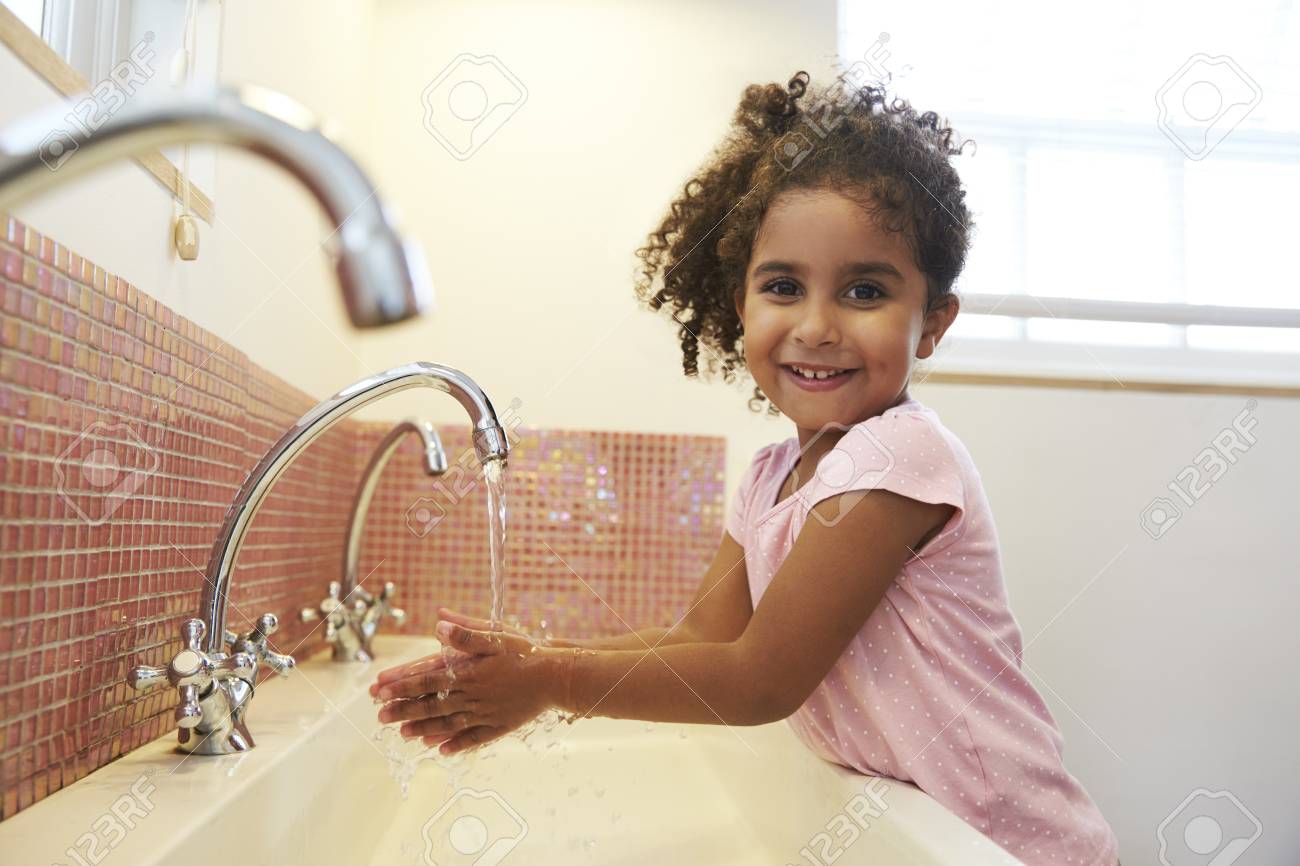 Female Pupil At Montessori School Washing Hands In Washroom - 79574129 Female Pupil At Montessori School Washing Hands In Washroom - 79574129