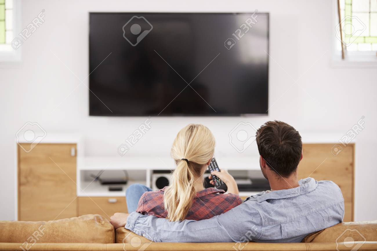 Rear View Of Couple Watching Television Together - 86206660 Rear View Of Couple Watching Television Together - 86206660