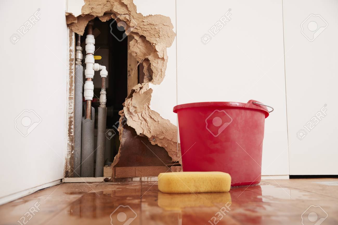 Damaged wall, exposed burst water pipes, sponge and bucket - 91652607 Damaged wall, exposed burst water pipes, sponge and bucket - 91652607