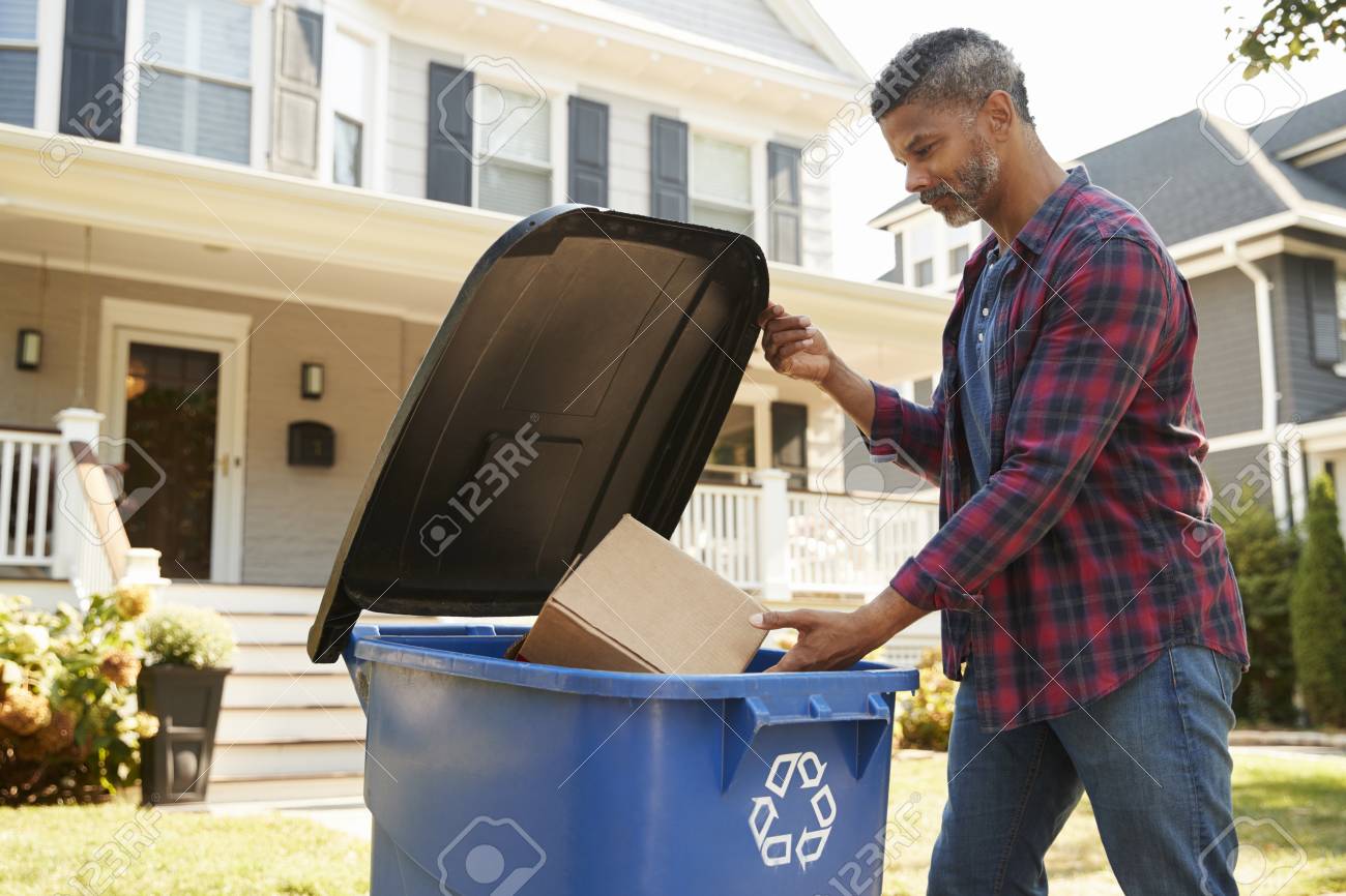 Man Filling Recycling Bin On Suburban Street - 93401657 Man Filling Recycling Bin On Suburban Street - 93401657