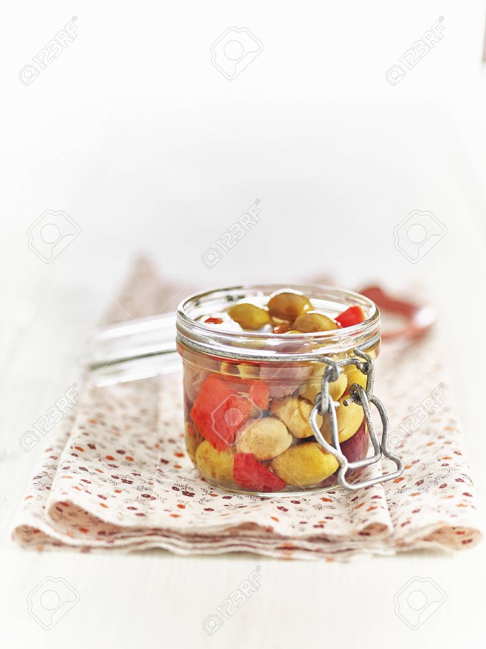lacto fermented green olives and red peppers in a mason jar stock