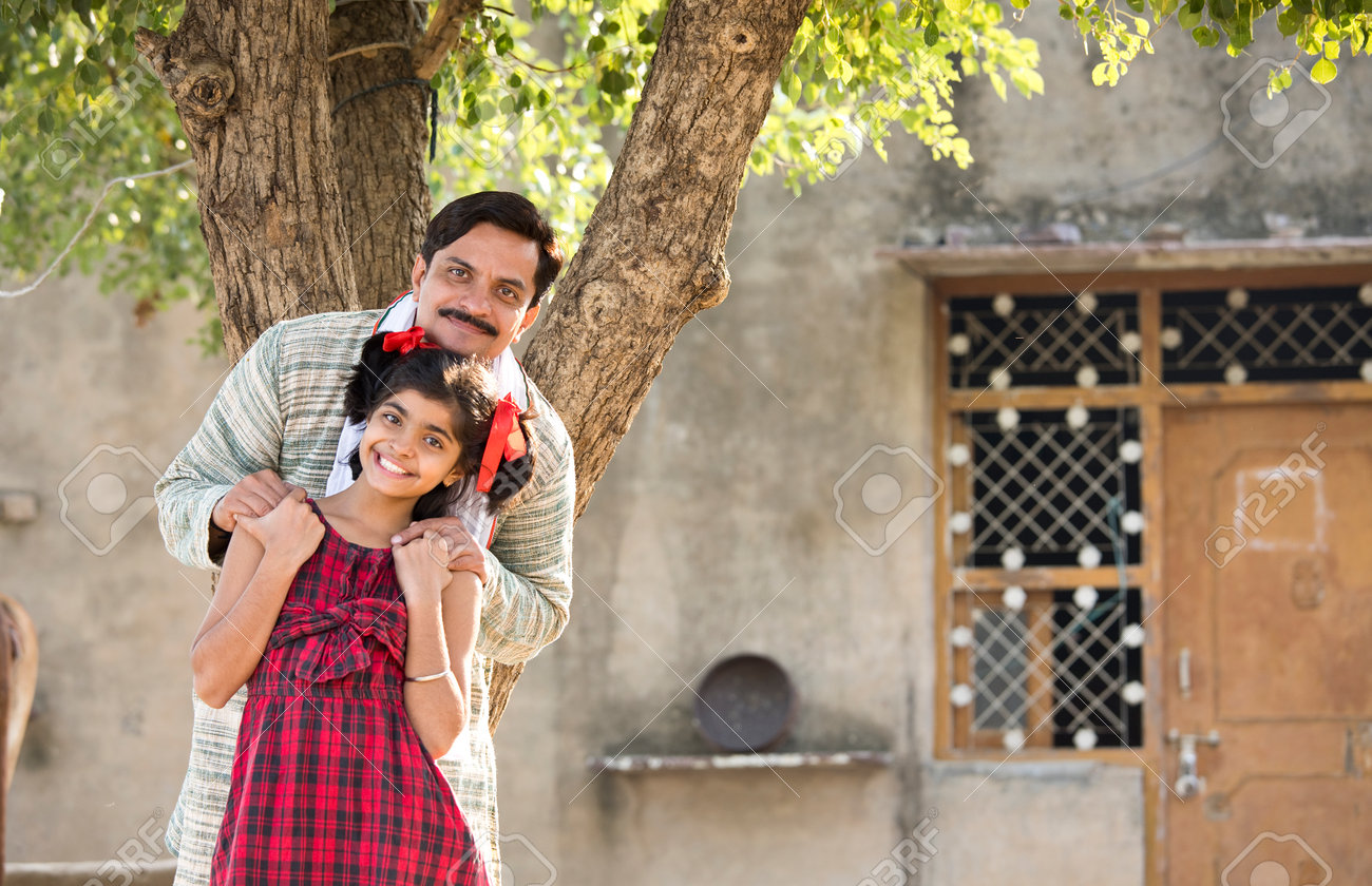 Rural Indian Father With Daughter Looking At Camera Stock Photo 