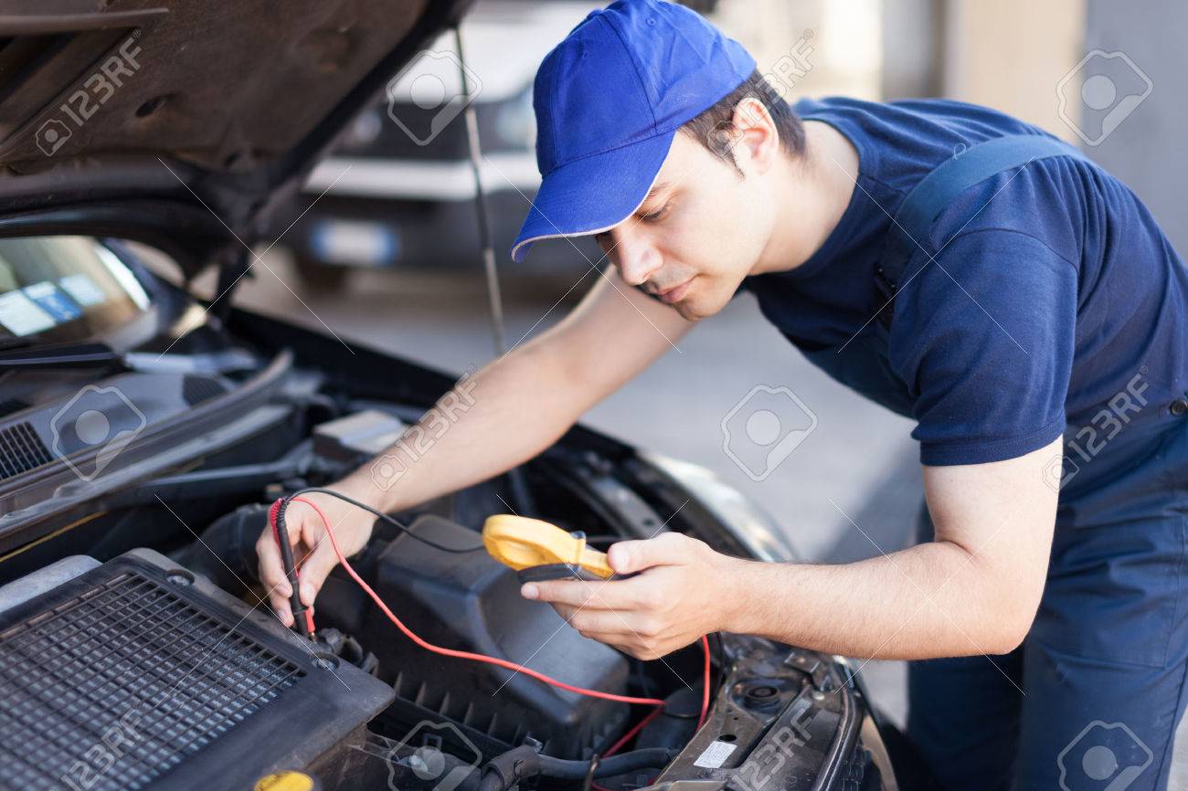 Auto electrician troubleshooting a car engine Stock Photo - 31043498