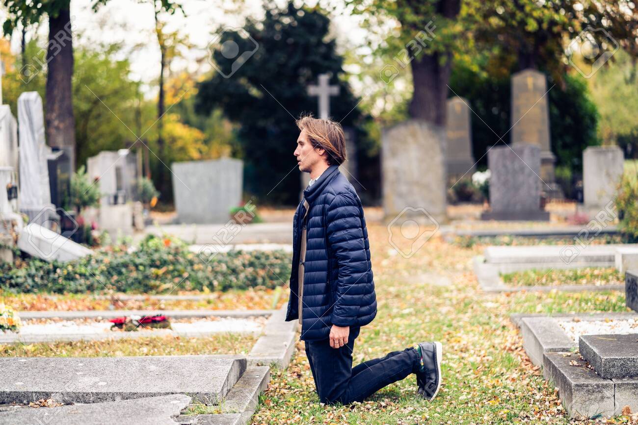 https://previews.123rf.com/images/stockme/stockme1911/stockme191100029/133902817-mourning-young-man-kneeling-in-front-of-a-grave-on-a-cemetery-during-a-sad-autumn-day.jpg
