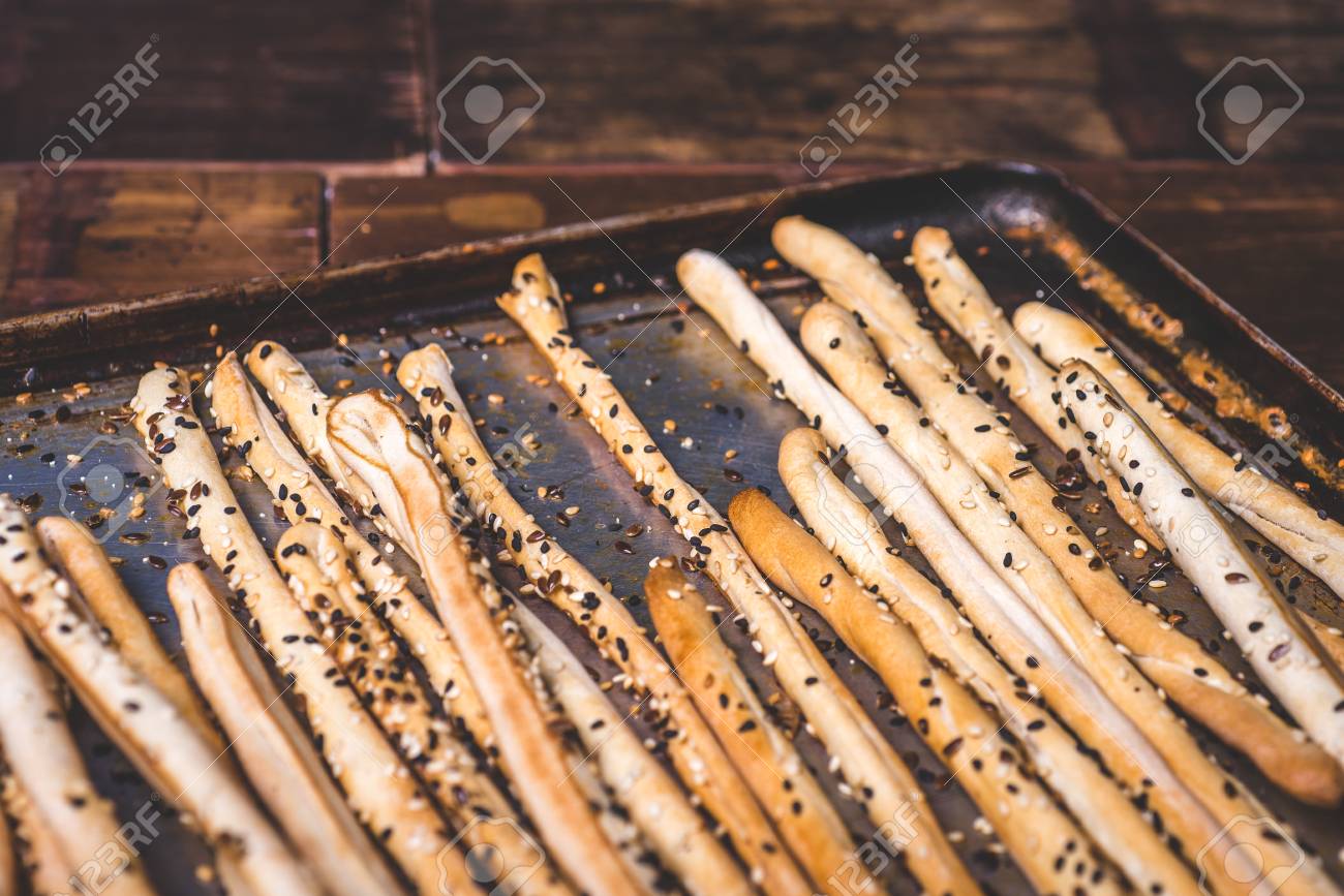 Bread sticks and a baking tray are strewn with seeds. - 92865377 Bread sticks and a baking tray are strewn with seeds. - 92865377