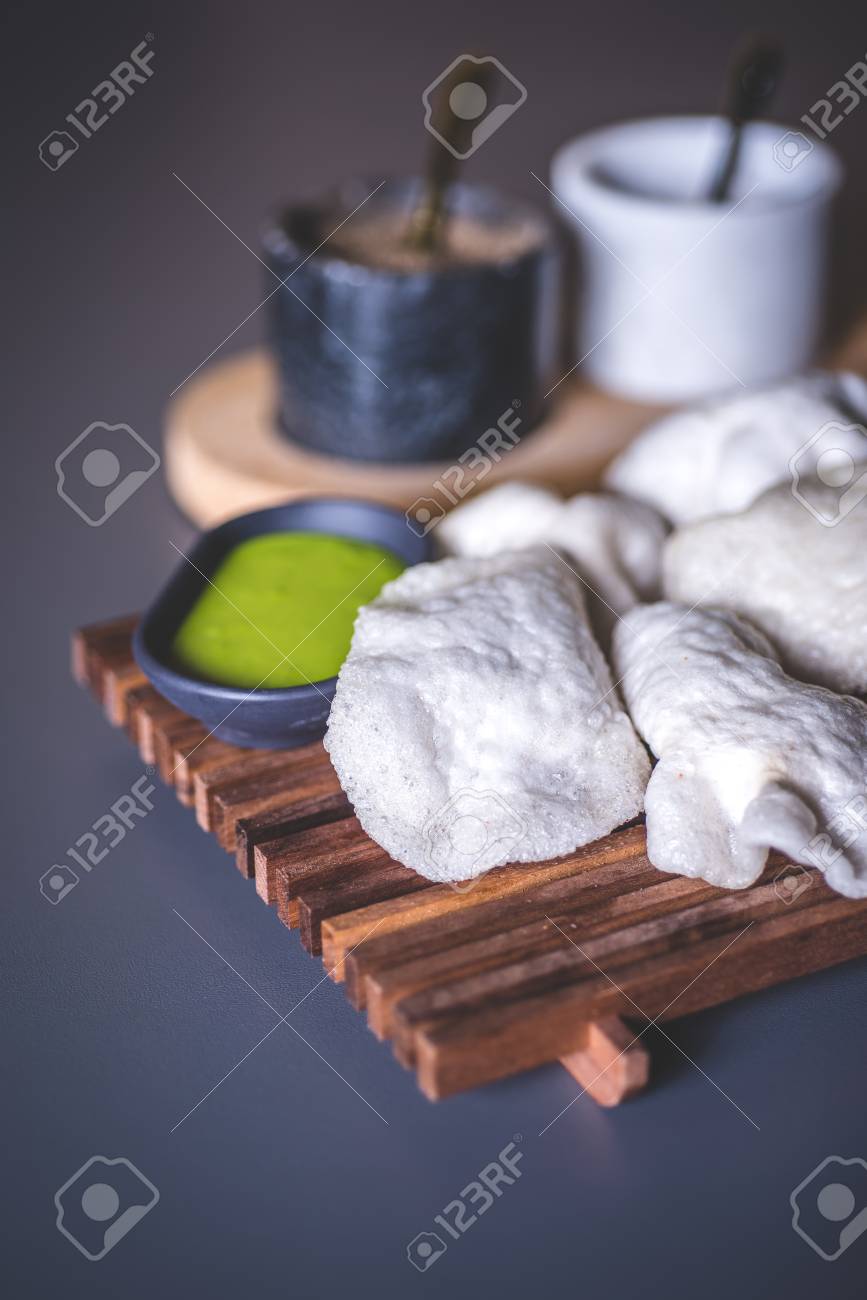 Close-up of crispy white patties near the dish with sauce. Marble glasses with spices in the background. - 93217203 Close-up of crispy white patties near the dish with sauce. Marble glasses with spices in the background. - 93217203