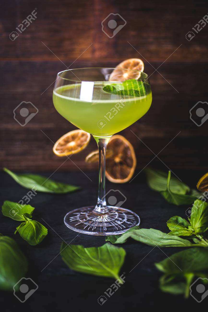 Cocktail on the background of falling lemon slices. - 99535129 Cocktail on the background of falling lemon slices. - 99535129