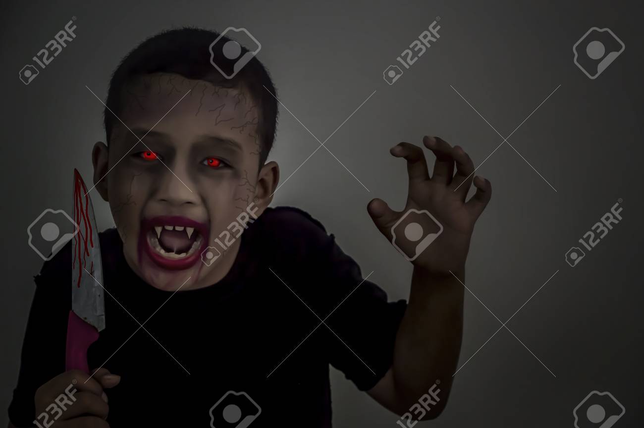Child dressed Halloween costume. Kid painted terrible vampire..