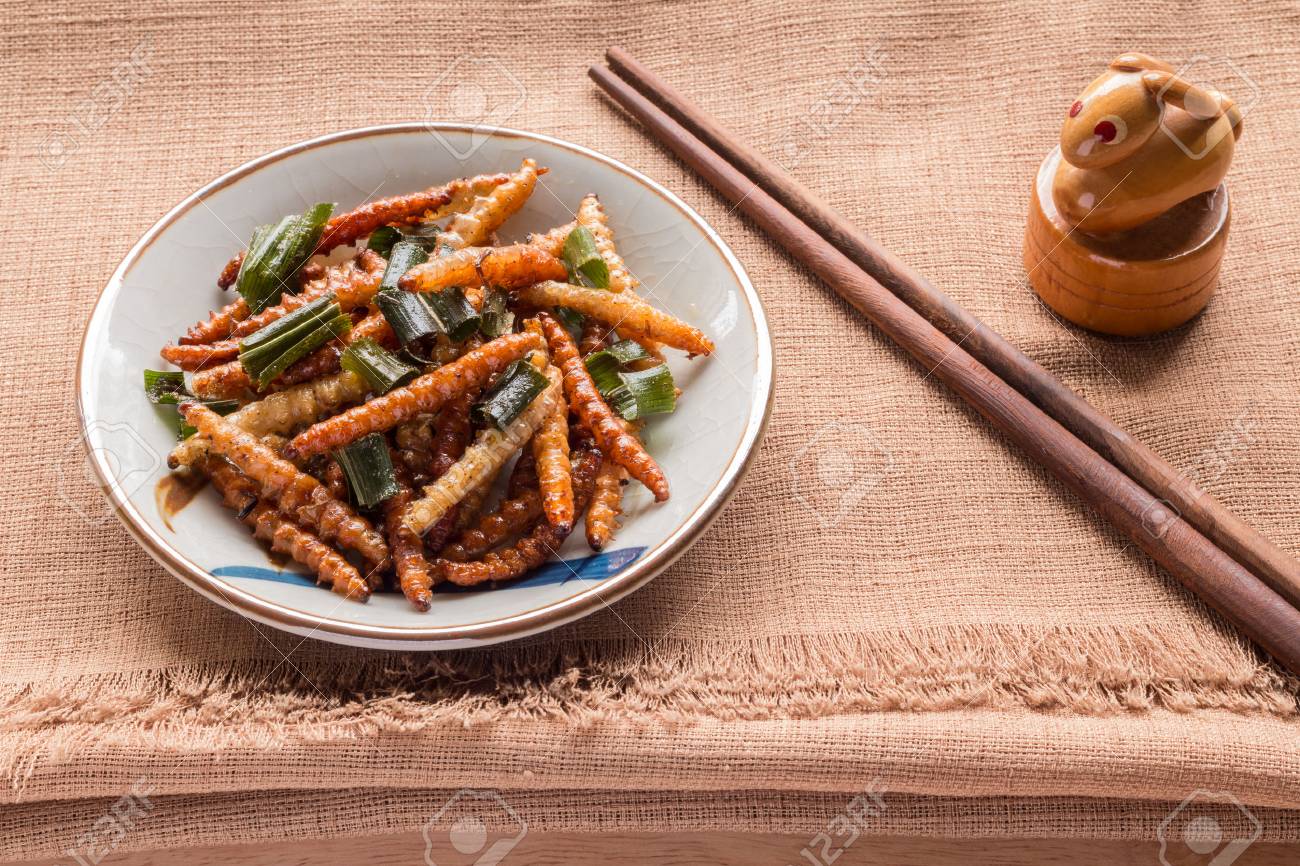 Fried insects - Wood worm insect crispy with pandan after fried and add a light coating of sauce and garnish Thai pepper powder and chopsticks on brown cloth background, select focus - 61935575 Fried insects - Wood worm insect crispy with pandan after fried and add a light coating of sauce and garnish Thai pepper powder and chopsticks on brown cloth background, select focus - 61935575