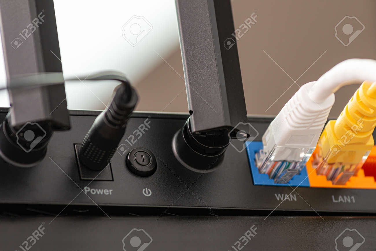 Wireless internet router with connected cables, The backside of fiber optic internet, and network cables connected to a router. Internet security and hi-speed concept. Selective focus.. Close-up - 166001365 Wireless internet router with connected cables, The backside of fiber optic internet, and network cables connected to a router. Internet security and hi-speed concept. Selective focus.. Close-up - 166001365