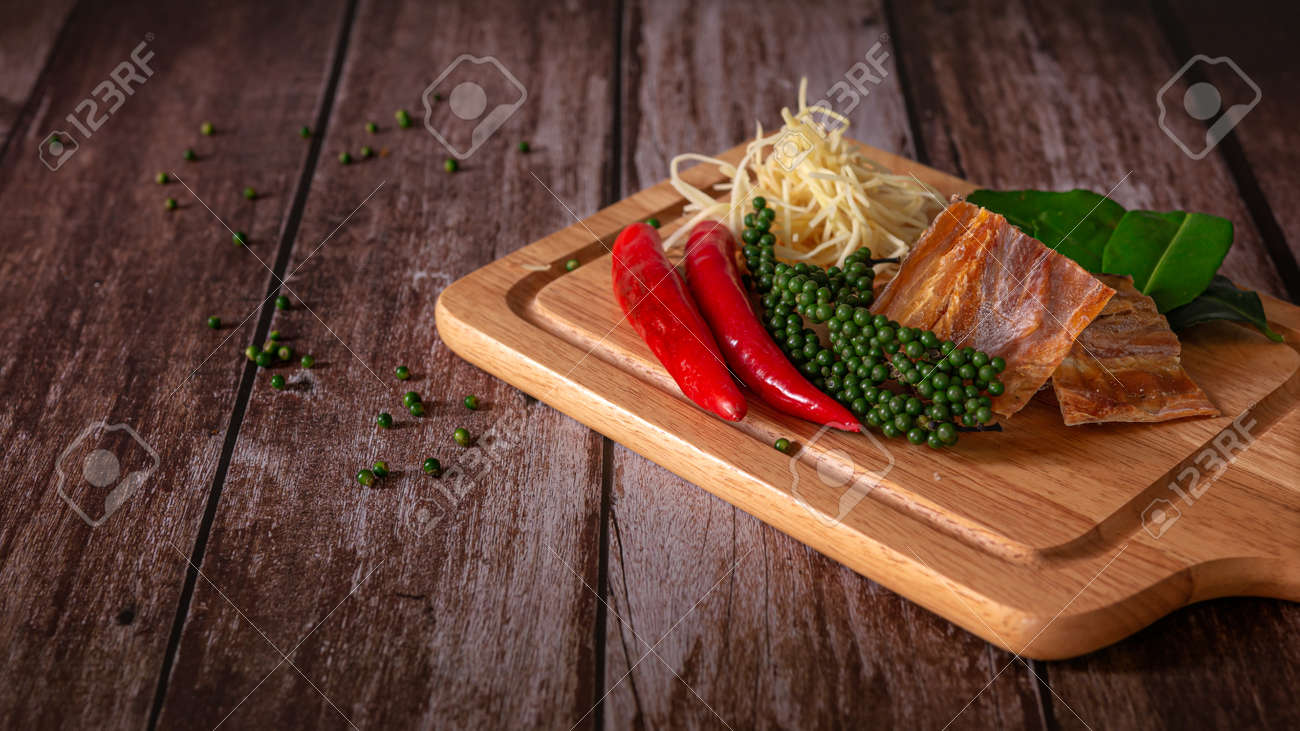 Spices with ingredients, Stir-Fried Spicy and herb with dried fish fillet on a cutting board with wooden dark background. Thai food concept. - 166001378 Spices with ingredients, Stir-Fried Spicy and herb with dried fish fillet on a cutting board with wooden dark background. Thai food concept. - 166001378