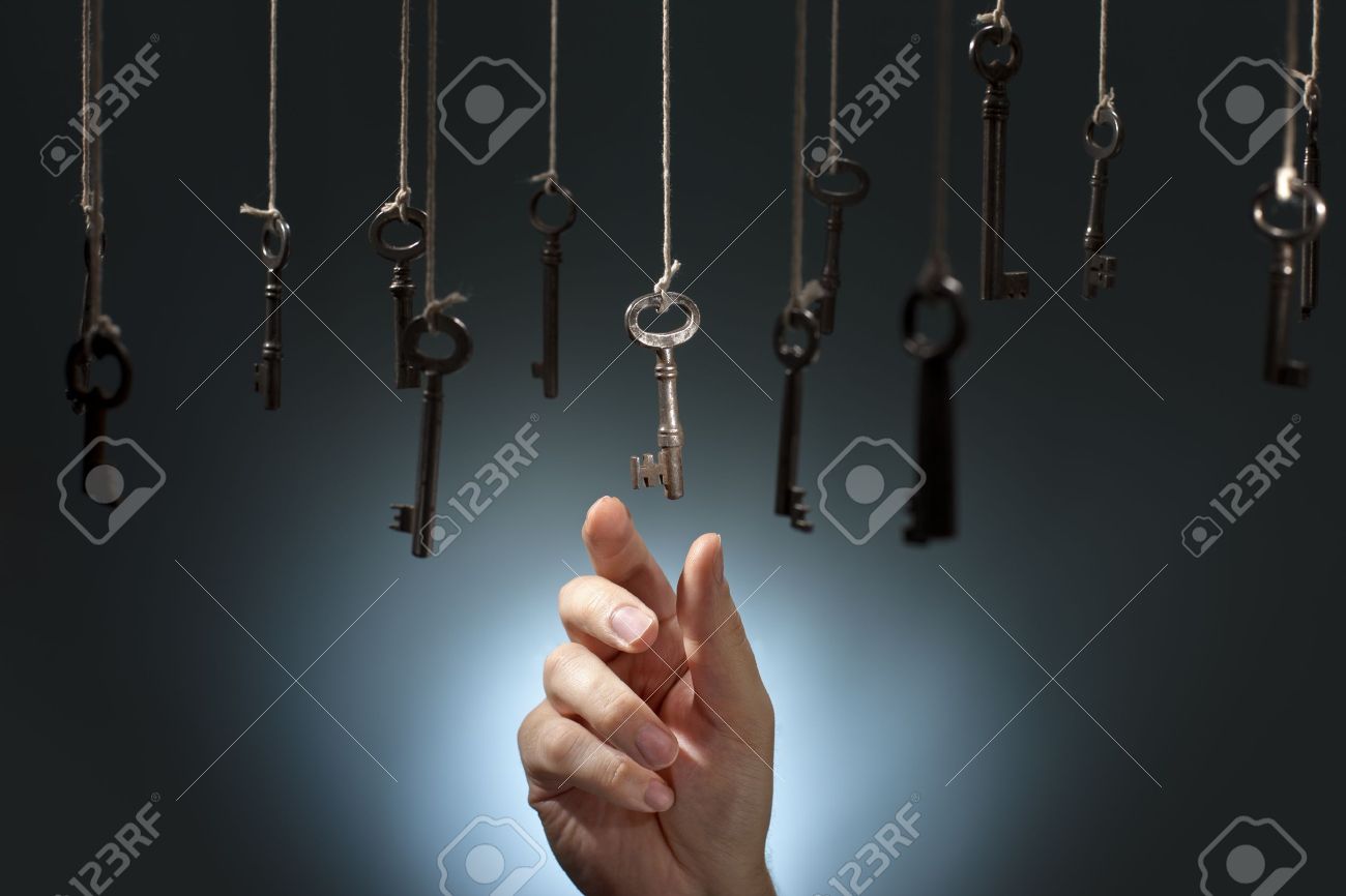 hand choosing a hanging key amongst other ones stock photo picture