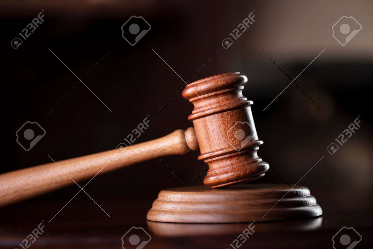 Lawyer office. Gavel on brown shining desk and collection of legal books in the bookshelf. - 168775418 Lawyer office. Gavel on brown shining desk and collection of legal books in the bookshelf. - 168775418
