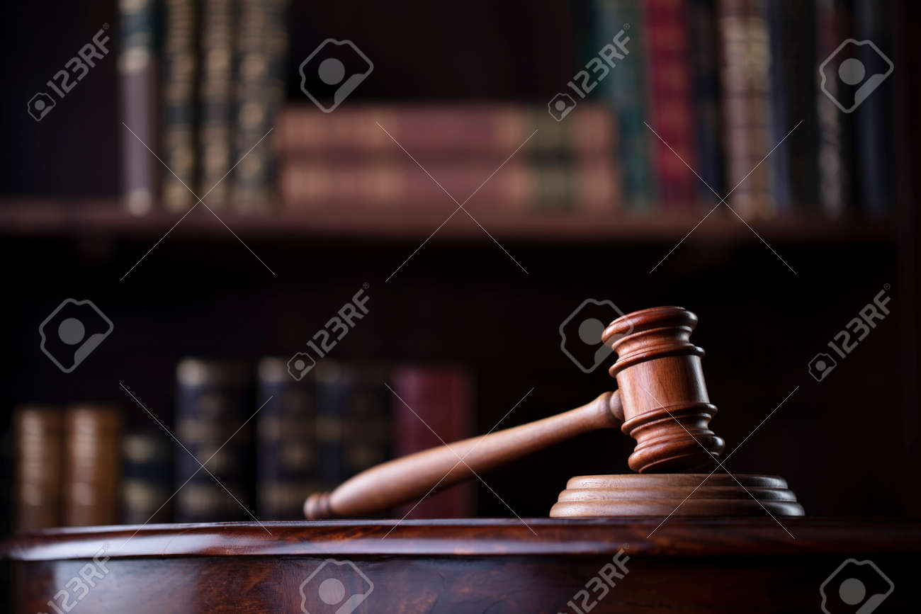Lawyer office. Gavel on brown shining desk and collection of legal books in the bookshelf. - 168775421 Lawyer office. Gavel on brown shining desk and collection of legal books in the bookshelf. - 168775421