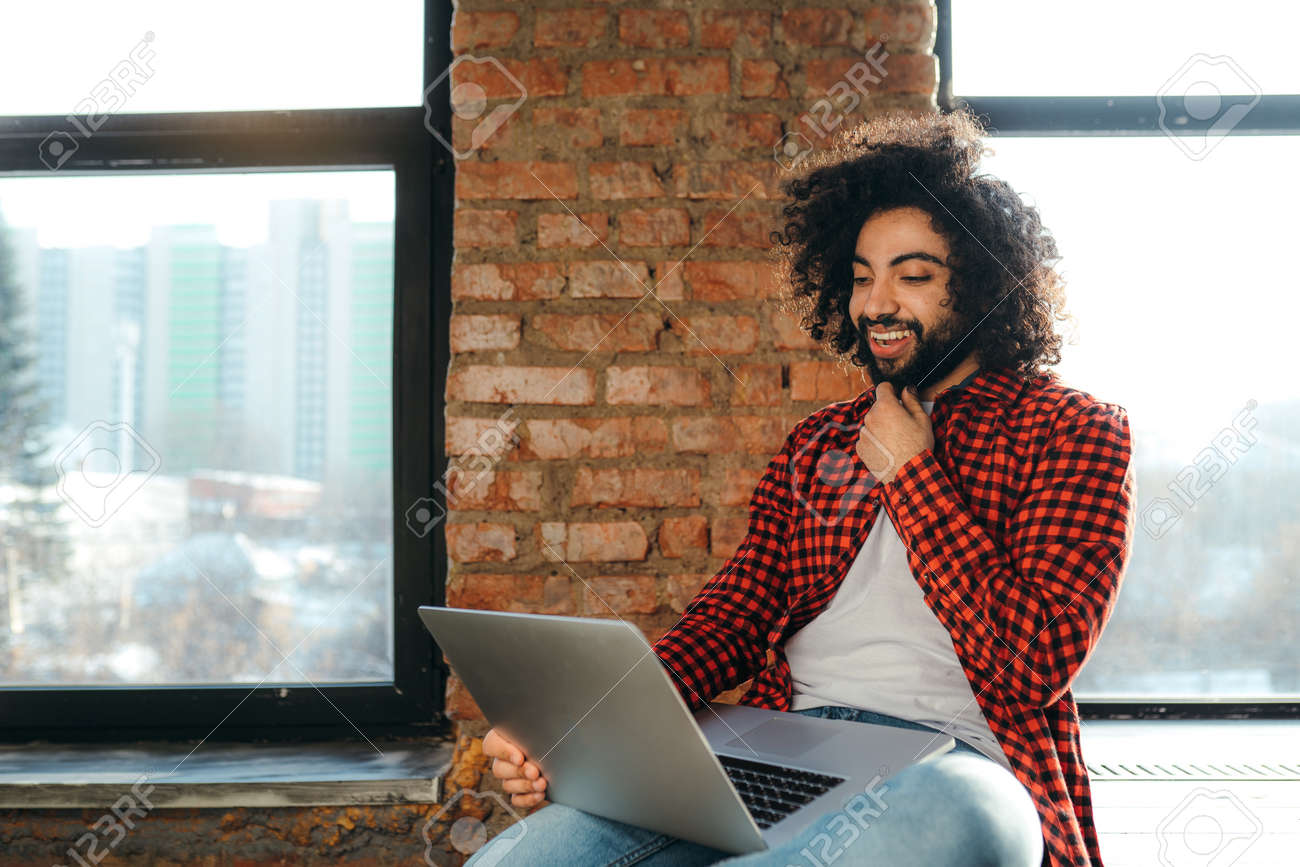 Handsome Smiling Egyptian Man With Beard Sitting On Floor Against Brick  Wall Background And Working In Laptop Stock Photo, Picture and Royalty Free  Image. Image 165849200., image size:1300x867